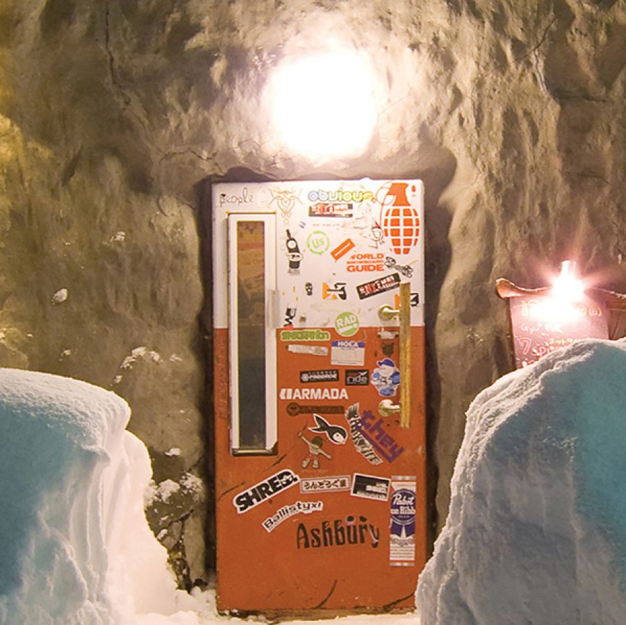 The exterior of Bar Gyu+ in Niseko in winter, with snow piling up on both sides of the doorway.