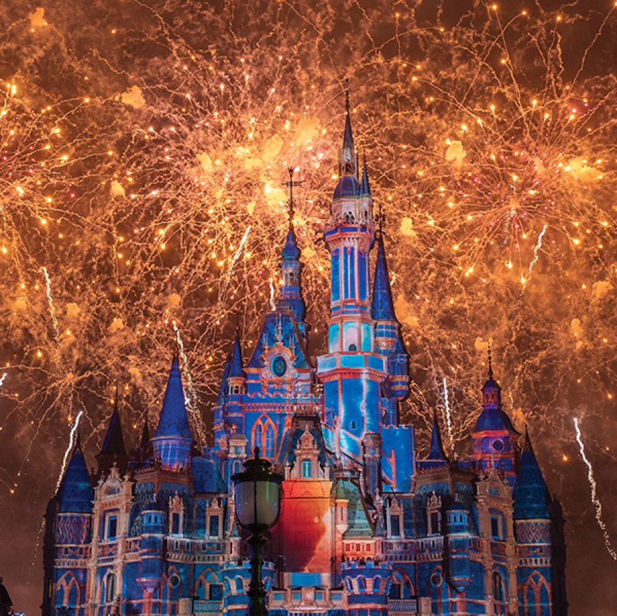Bright golden fireworks light up the night sky behind the Enchanted Storybook Castle at Shanghai Disneyland.