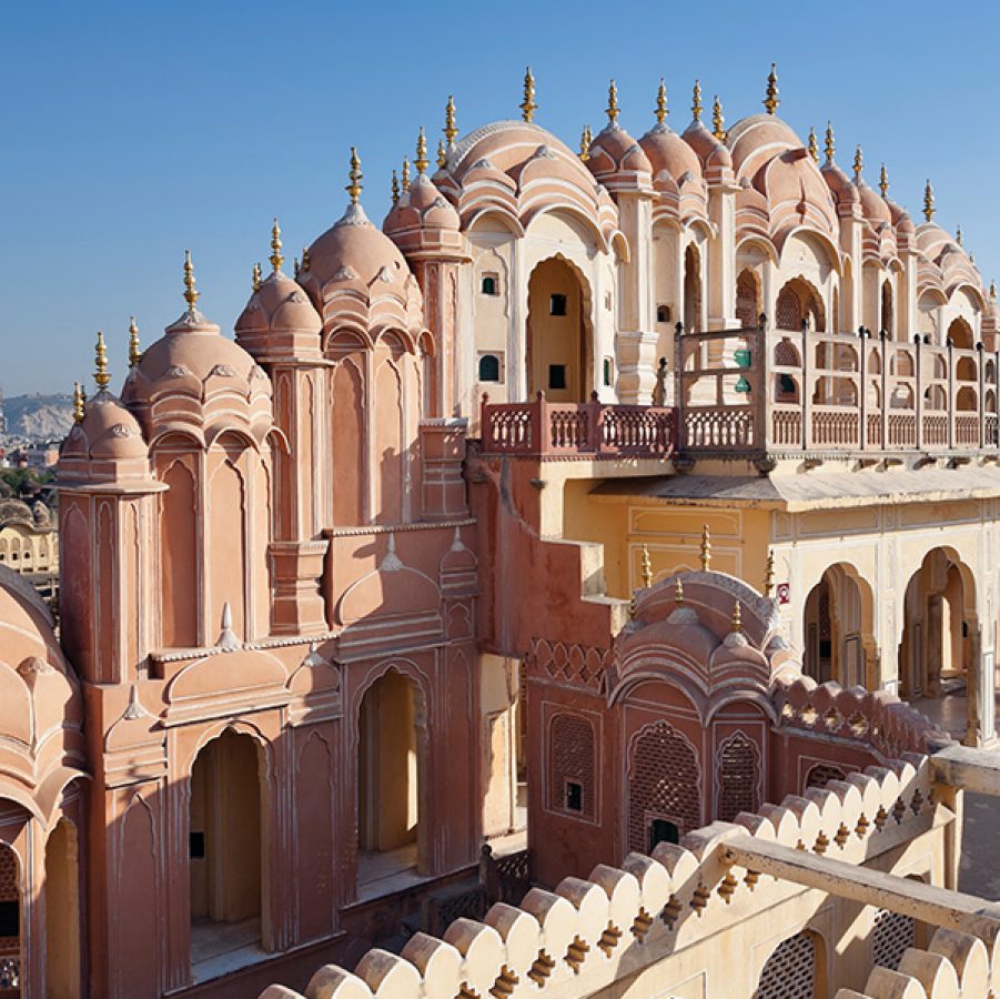 Person stands on a rooftop terrace of a pink building in Delhi.