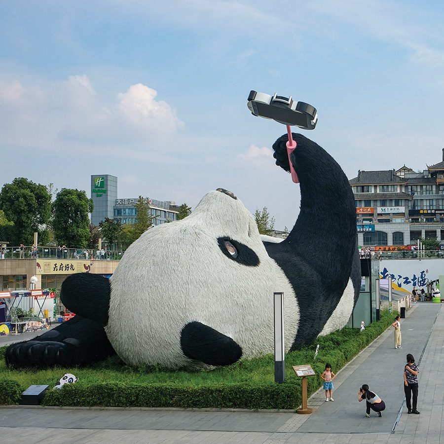 Gigantic statue of a panda holding up a selfie stick