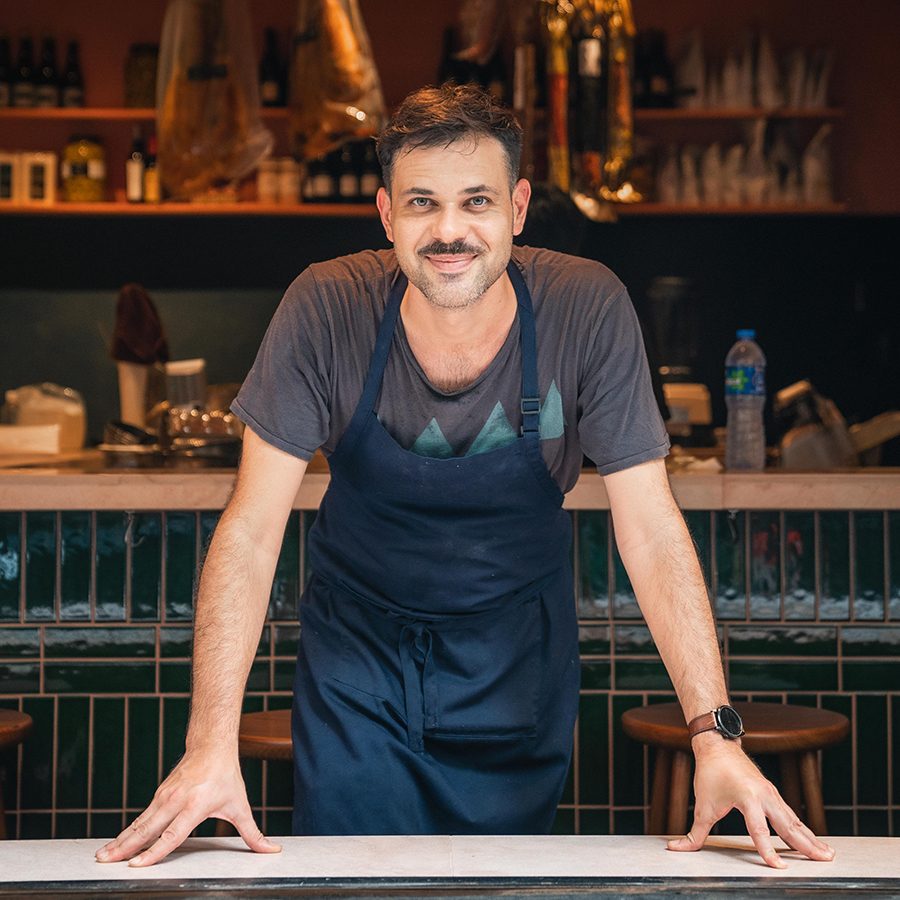 Antonio Oviedo, executive chef at 22 Ships, stands in front of a restaurant counter and poses for a picture.