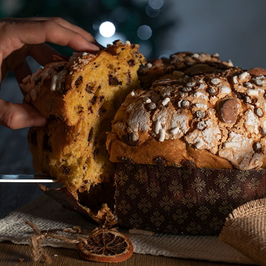 A chef cutting into a panettone, a traditional Christmas cake from Italy.