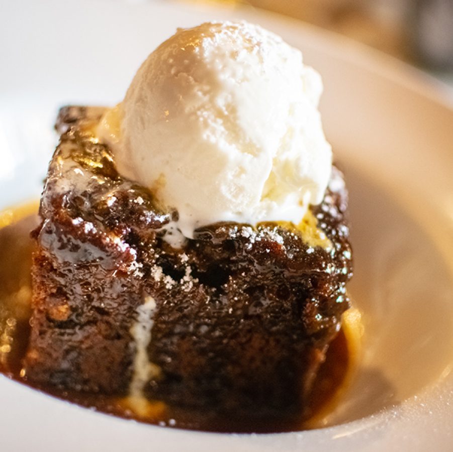 Sticky toffee pudding topped with vanilla ice cream is placed at the centre of a plate. It’s Barry Quek’s (head chef at Whey) favourite festive dish.