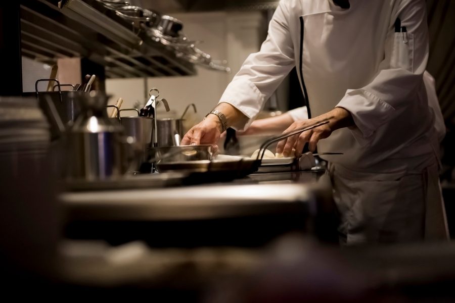 A chef prepares a dish in a restaurant kitchen during the Christmas festive season. 