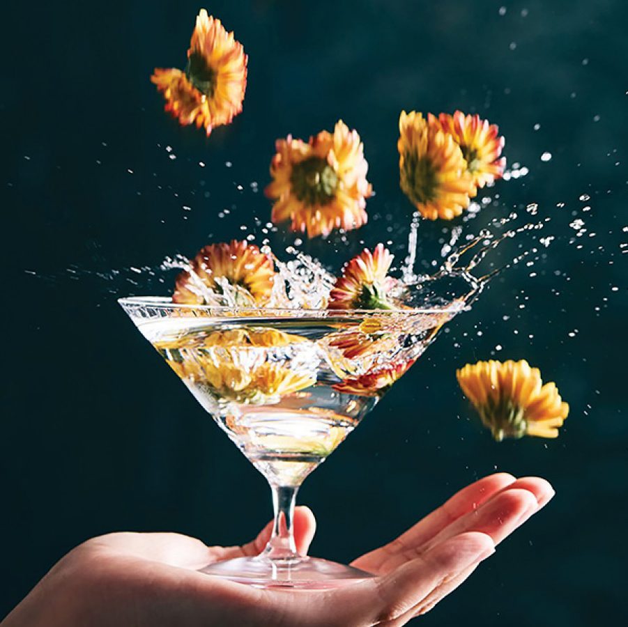 Marigold flowers dropping into a martini glass and splashing Belvedere vodka, served at Argo, Hong Kong.