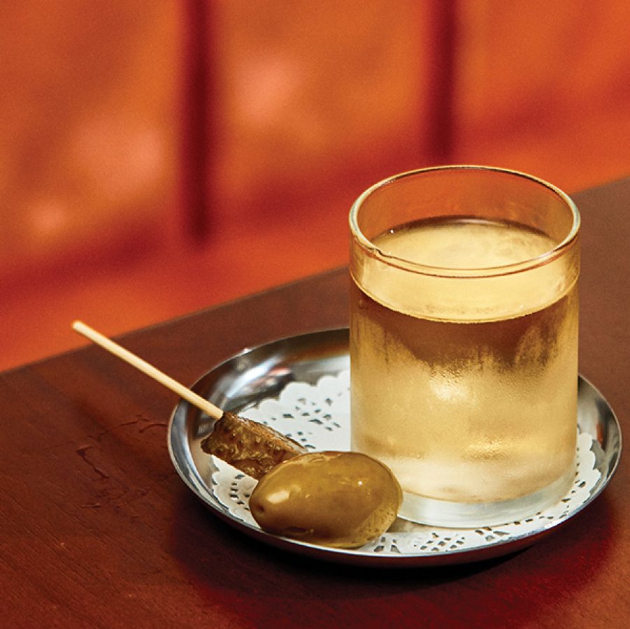 A close up of a Filthy Martini served in a whisky glass with smoked olives served at Bar Leone, Hong Kong.