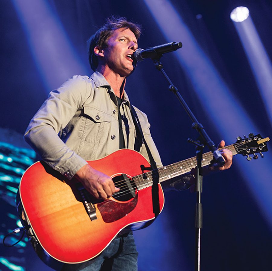 British singer James Blunt with a guitar singing on stage.