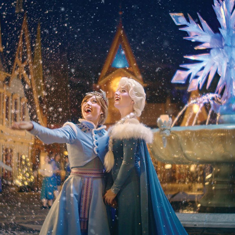 Actresses dressed as Frozen characters Princesses Elsa and Anna while snow falls at Hong Kong Disneyland.