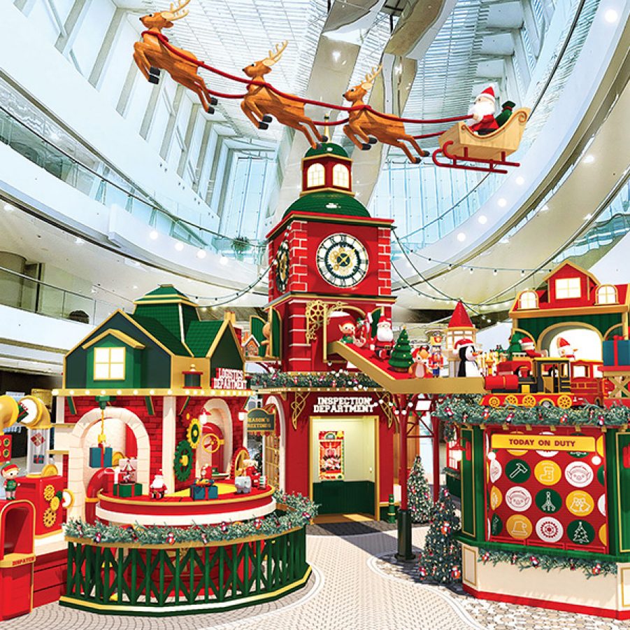 A Christmas North Pole toy factory installation with Santa on a sleigh and reindeers hanging above at IFC shopping mall in Central.