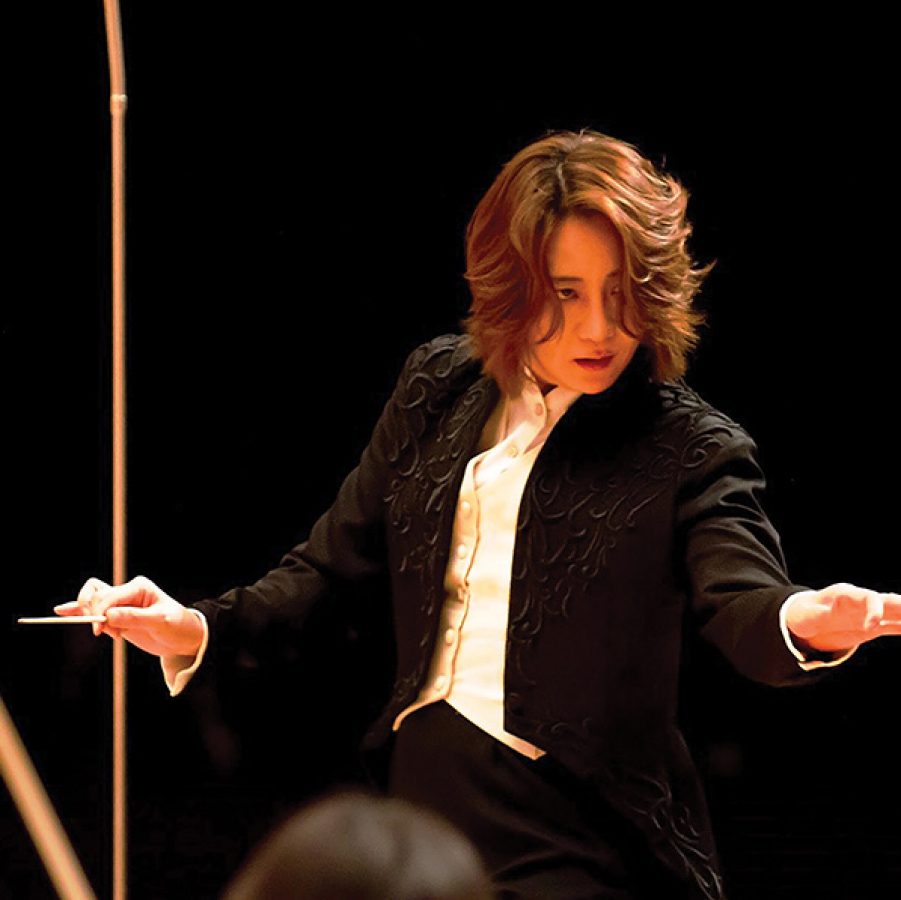 Musical conductor Tomomi Nishimoto from the IlluminArt Phillharmonic Orchestra on stage.