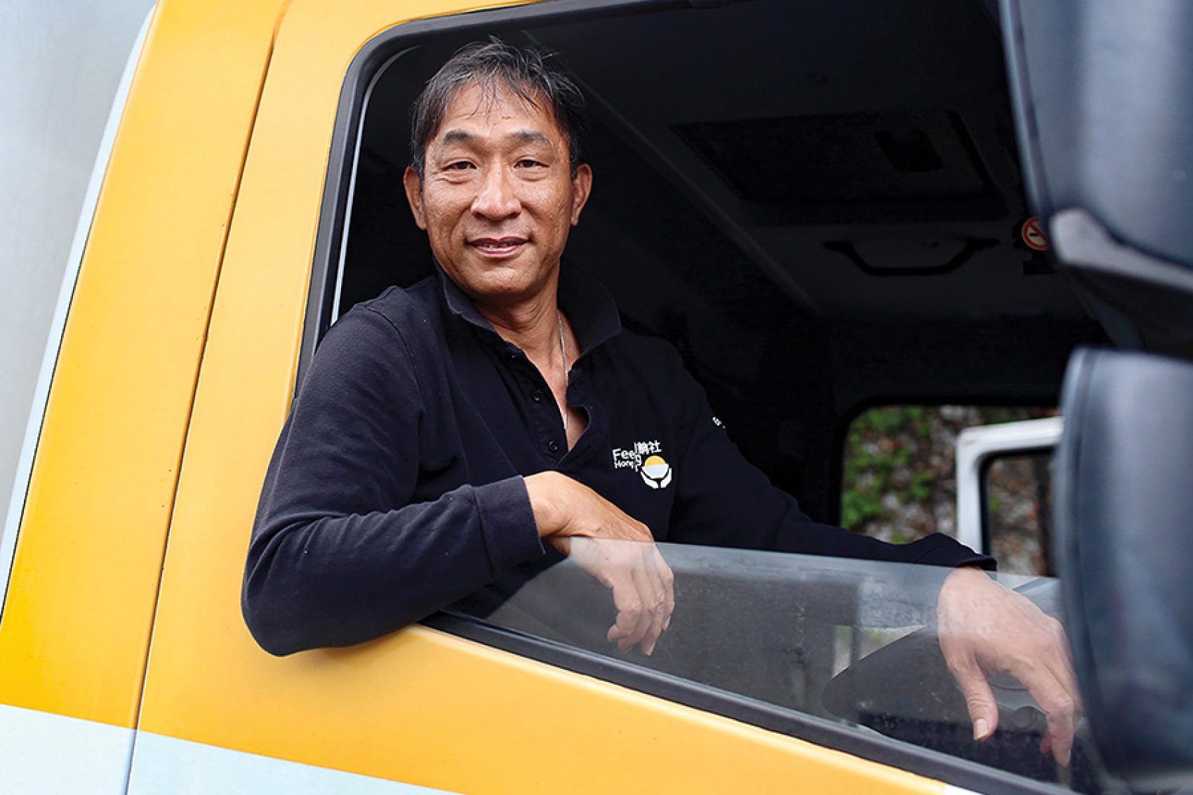 Portrait of a driver for Feeding Hong Kong inside a lorry. 