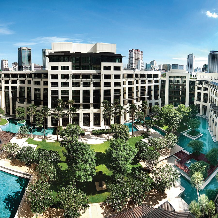 A bird’s eye view of the exterior of Siam Kempinski Hotel Bangkok and its free-form swimming pool