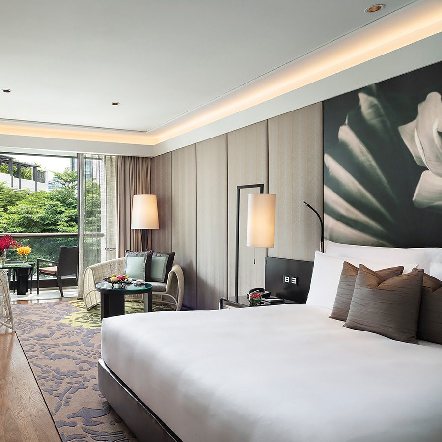 A view of the stylish interior of a guestroom with balcony facing the garden at Siam Kempinski Hotel Bangkok