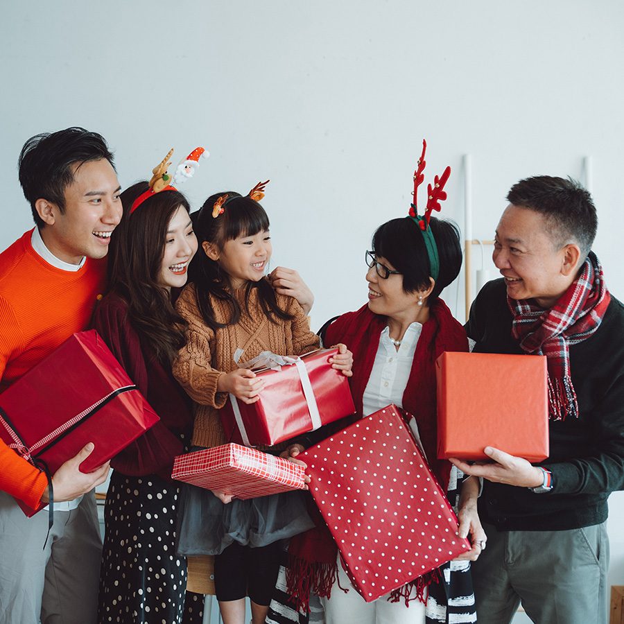 Family holding Christmas presents and wearing reindeer ears.
