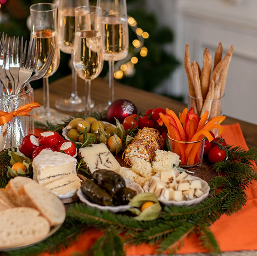 Close up shot of a Christmas-themed charcuterie board with glasses of champagne.