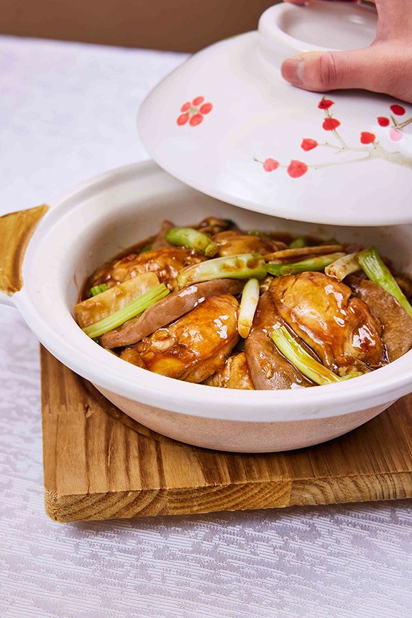 A close up of a braised pork liver and oysters with onion and ginger claypot rice, served at The Royal Garden Chinese Restaurant in Tsim Sha Tsui. 