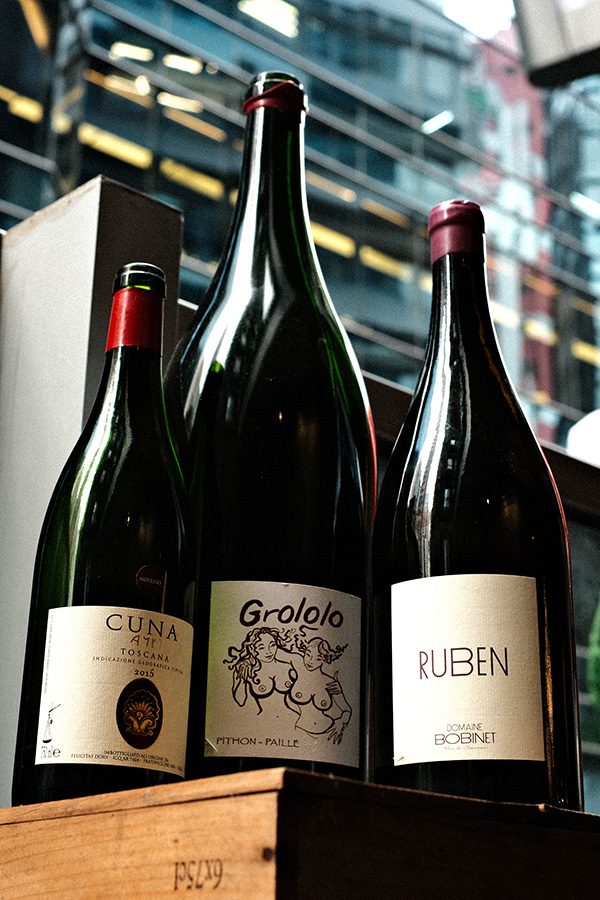 Three bottles of red wine selections, Cuna, Gralolo and Ruben, on a wooden crate, served at ThinkWine in SoHo, Central.