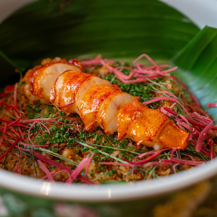 A closeup of a nasi ulam dish topped with charcoal-grilled lobster, served at Whey in Central.