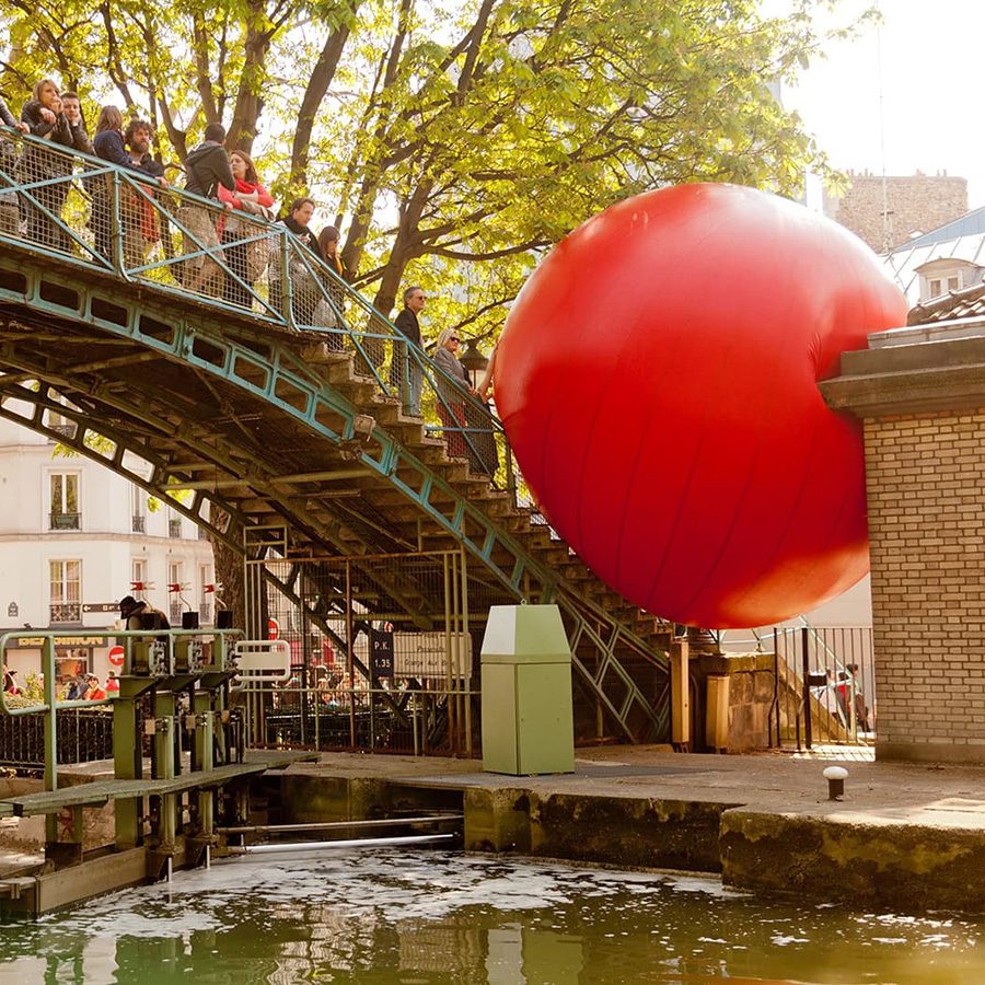 Top-bottom, Shot of American artist Kurt Perschke’s RedBall installation over a bridge. 