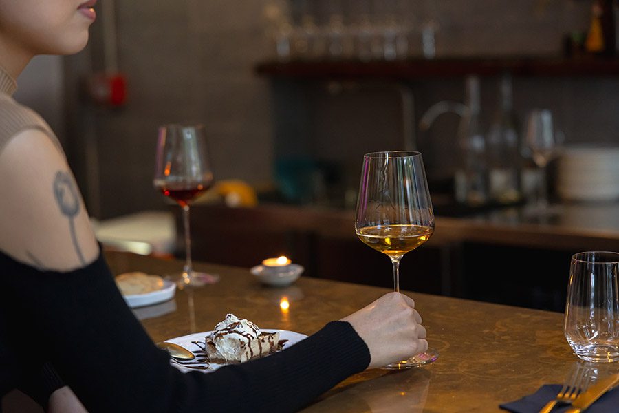 Woman holding a glass of wine at Crushed.