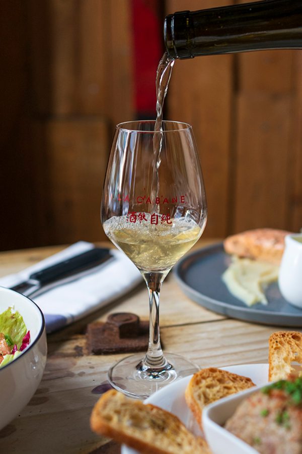 Shot of a glass of white wine and food at La Cabane Wine Bistro.