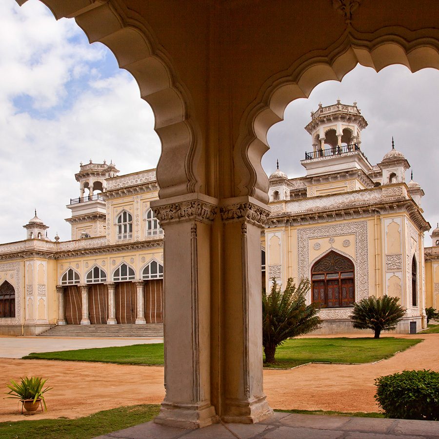 A view of Chowmahalla Palace in Hyderabad from under an arcade at daytime.