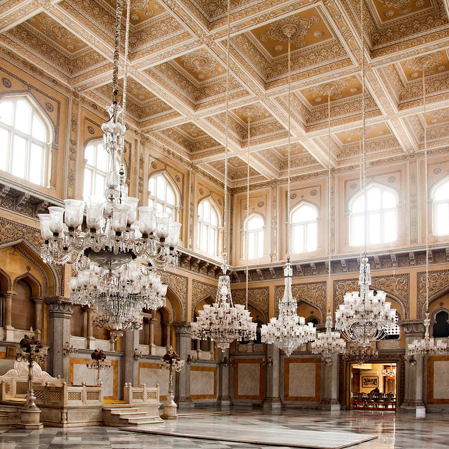Inside the yellow durbar hall inside Chowmahalla Palace, where a series of chandeliers hang from the ceiling.