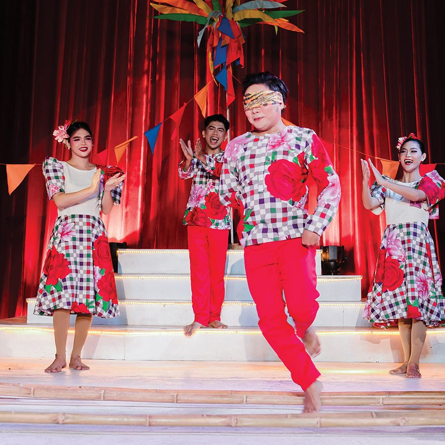 A blindfolded performer dances between poles as three other dancers clap onstage at White Note Pavilion in Cebu.