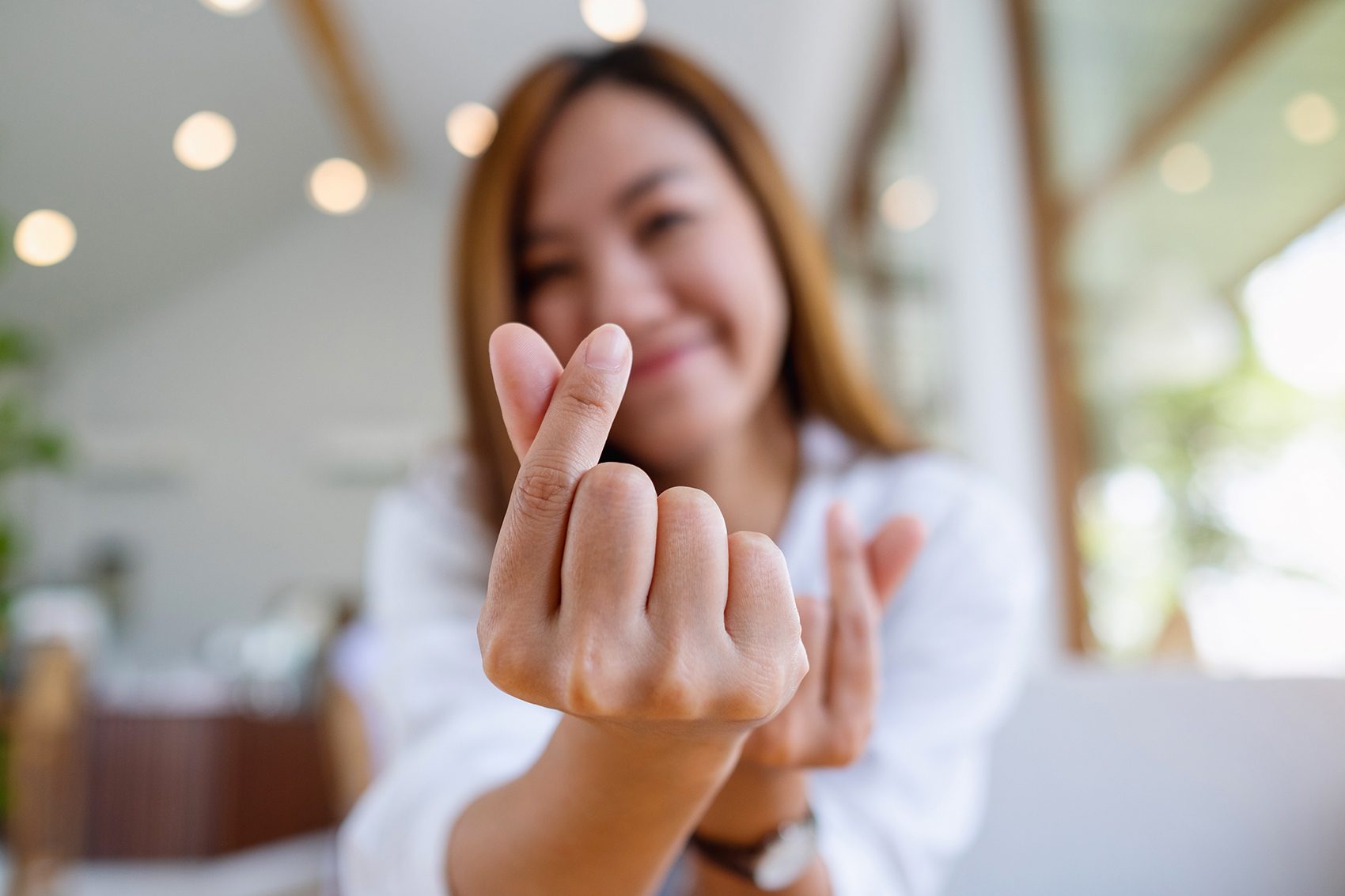 Woman making the Korean finger heart pose.