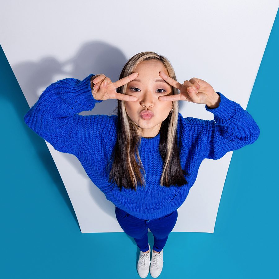Woman posing with double victory signs over her eyes.