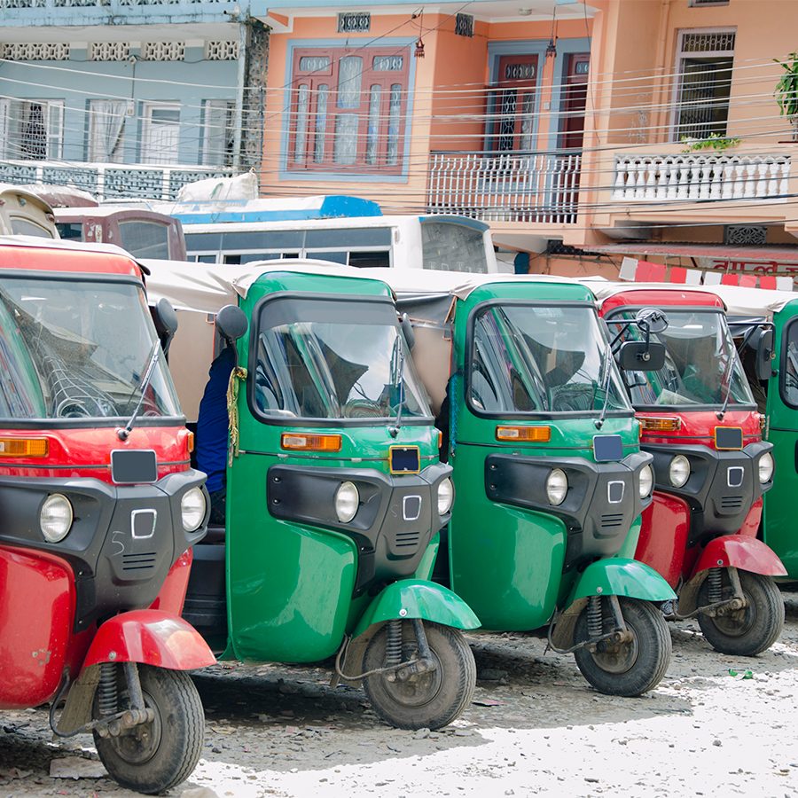 A row of tuk tuks in Kathmandu in the daytime.