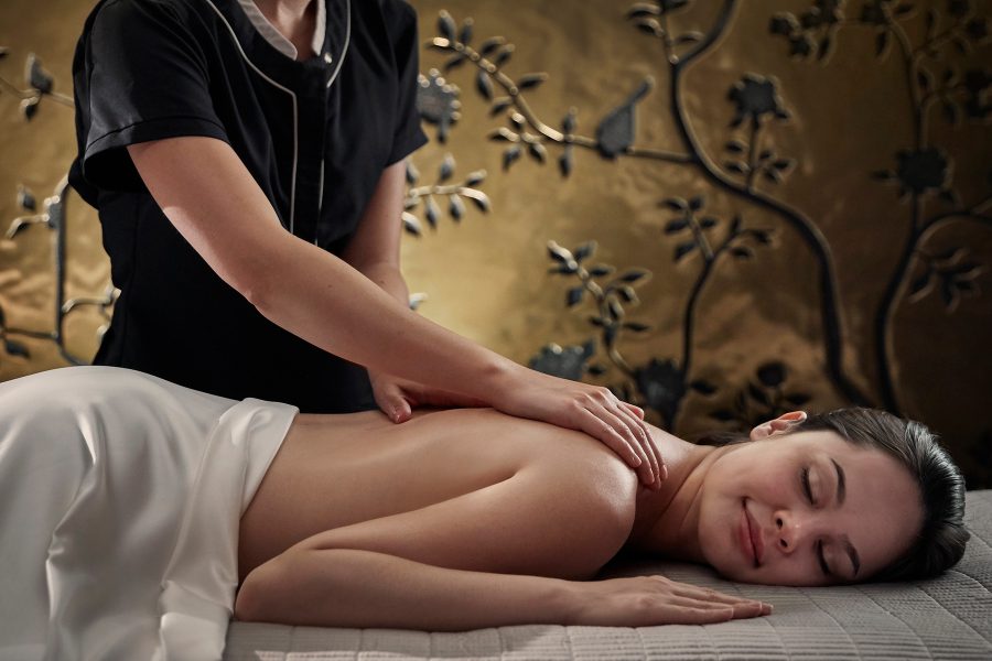 A woman lies face down as a therapist massages her back at Mandarin Oriental Hyde Park, London.