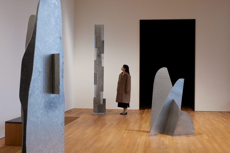 A woman standing in front of Isamu Noguchi’s Cloud Mountain, a sculpture made of steel plate.
