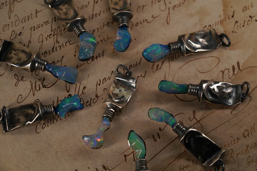 A collection of miniature silver paint tubes with blue-green paint.