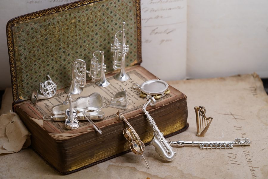 A collection of miniature silver musical instruments.