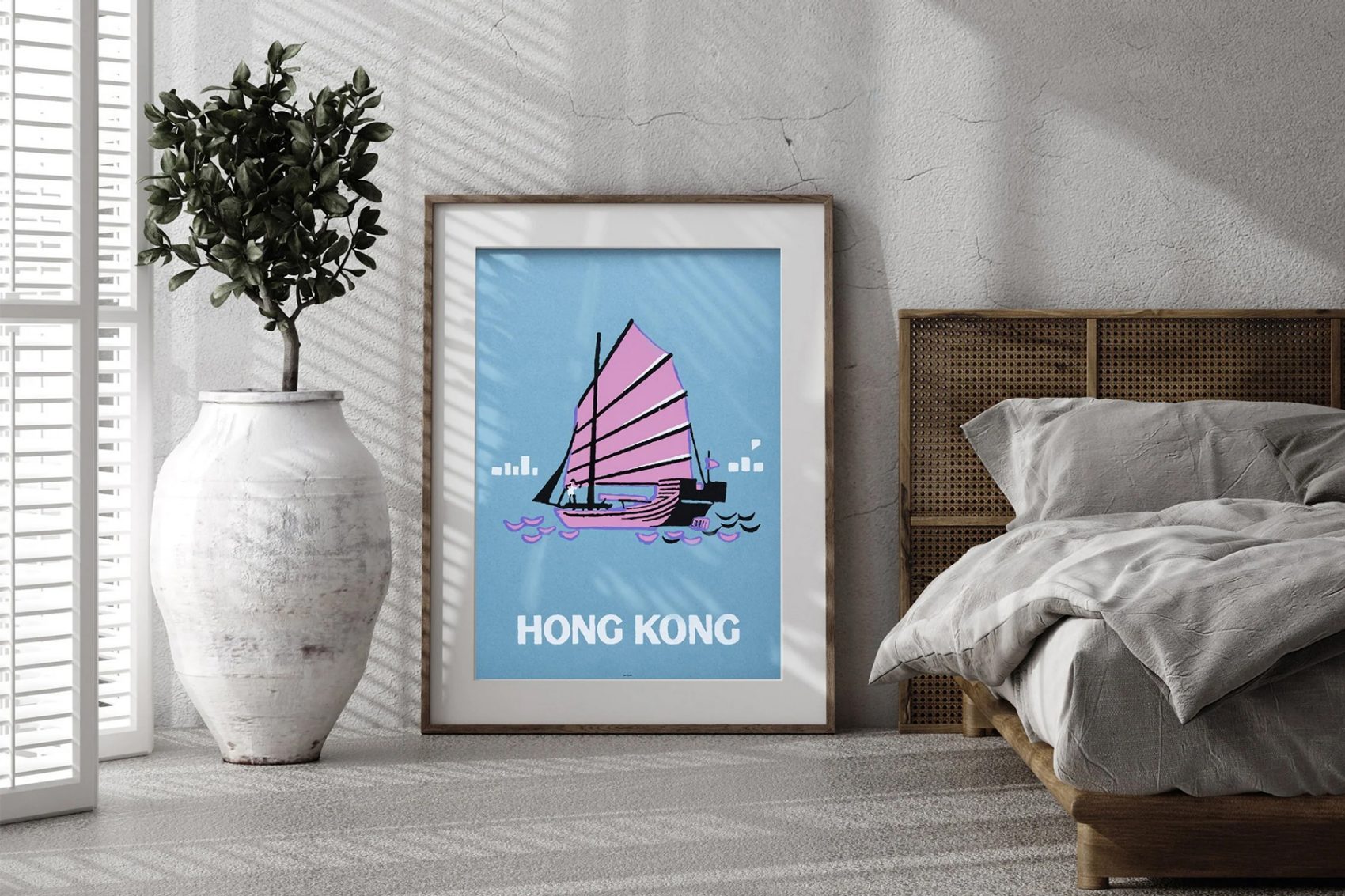 A framed print of a Hong Kong boat in a bedroom. 