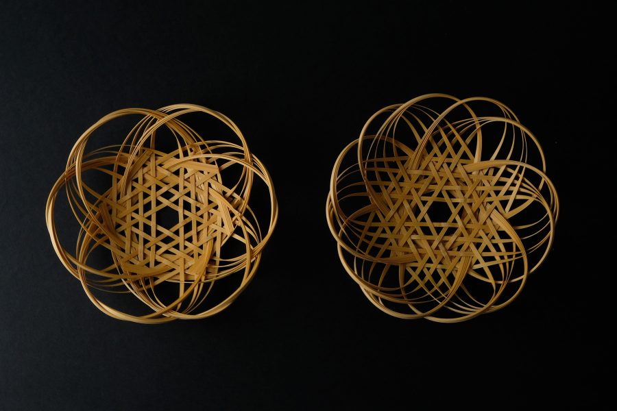Two circular woven objects on a black surface.