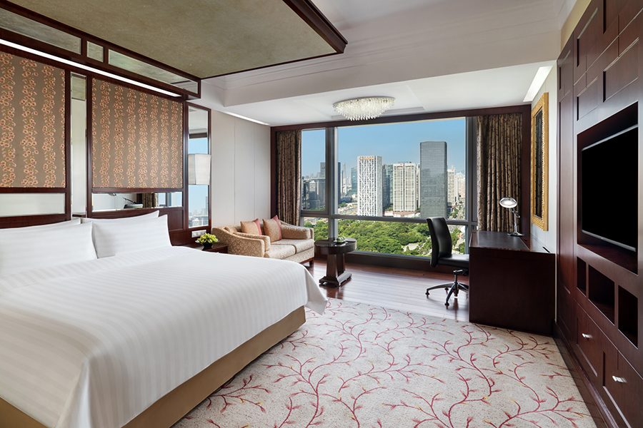 An interior view of a guestroom with city view at Shangri-La Shenzhen in China.