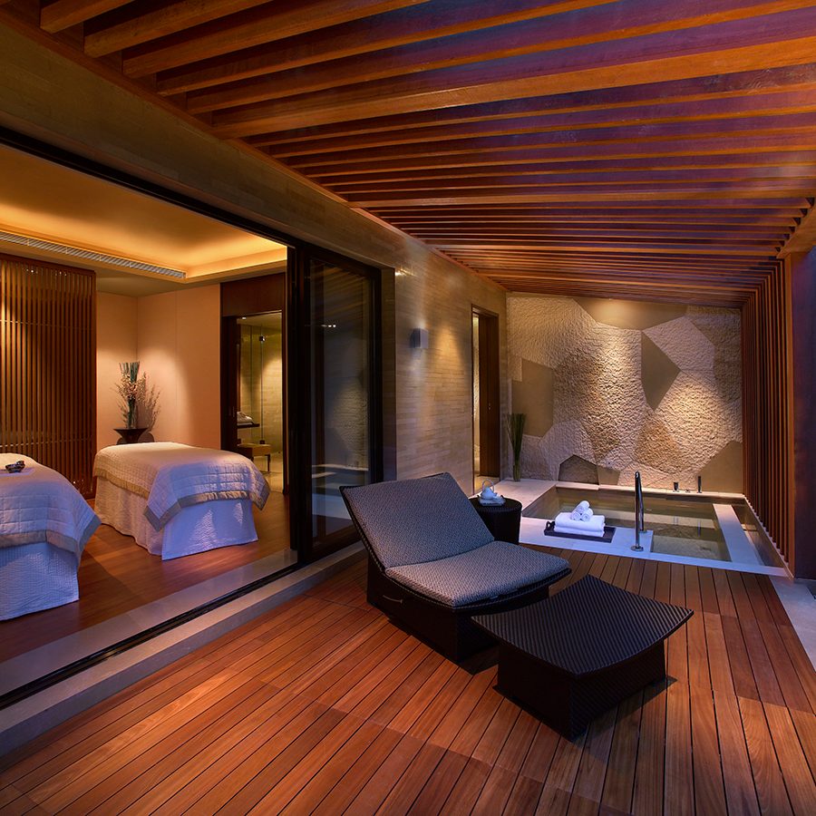 A view inside a spa room at Shui Xiang Spa, featuring two massage table, garden patio and bath at Grand Hyatt Shenzhen hotel in China.