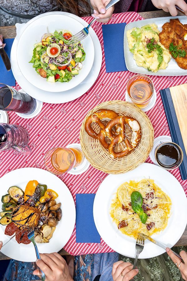 Flat lay of four diners eating at a beer garden. 
