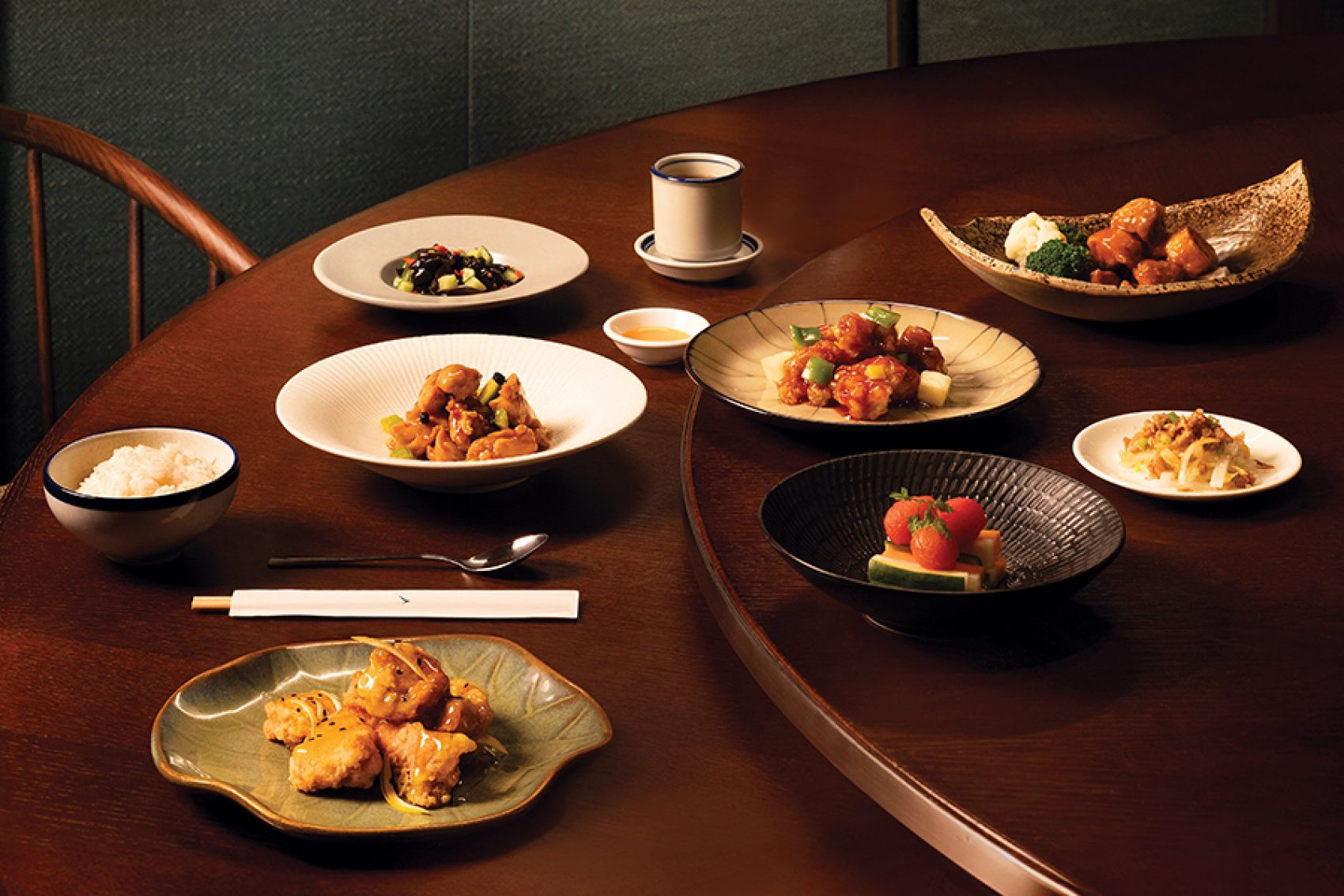 A group shot of classic Cantonese dishes on a round wooden table at Michelin-starred Yat Tung Heen Chinese restaurant in Hong Kong.