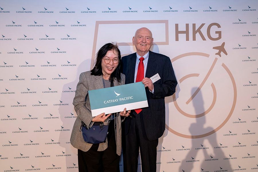 Captain Hal Dyball holds a large Cathay Pacific envelope next to a female attendee at Cathay’s celebration in Sydney.