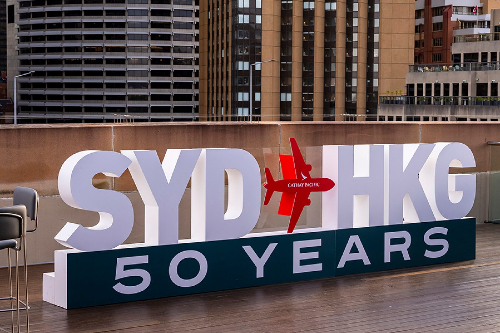 A large text display spelling out “SYD HKG 50 YEARS” in Sydney. 