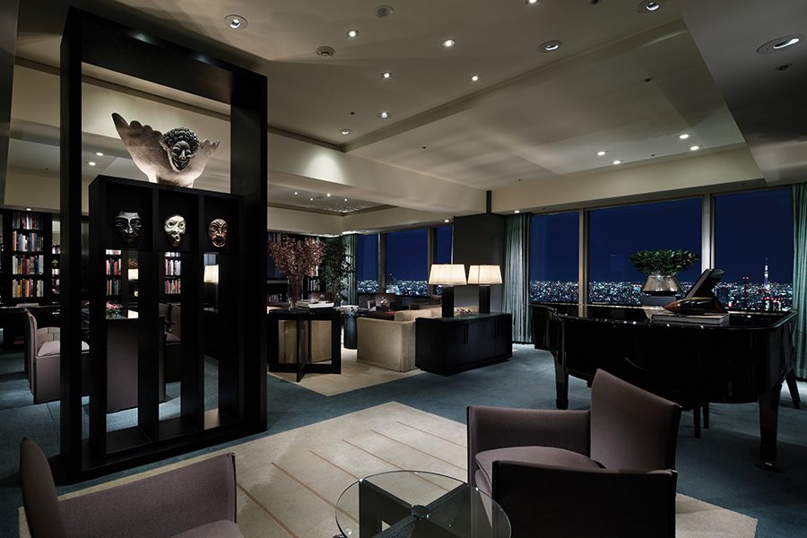 Interior of a lounging area with low couches and bookshelves in Park Hyatt Tokyo.