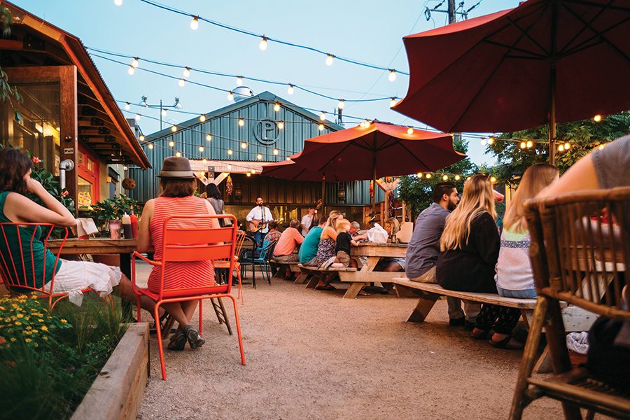 A street view of people enjoying a live show at Pecan Lodge in Dallas.