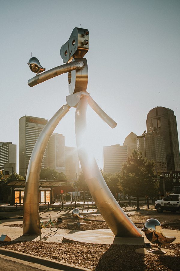 A large metal art installation outdoors on a sunny day in Dallas.