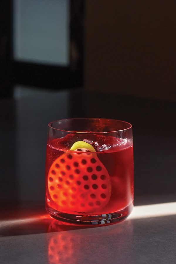 A close-up of a glass of red brahmi cocktail served at fine dining Ekka in Mumbai