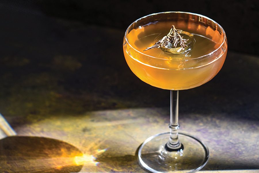 A close-up of a yellow cocktail Himalayan fir cocktail served at fine dining Ekka in Mumbai