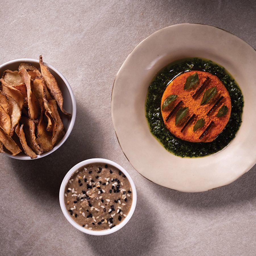 A flat lay of three dishes, masque podi cashew, curry leaf, and sunchoke chips served in fine dining Masque in Mumbai