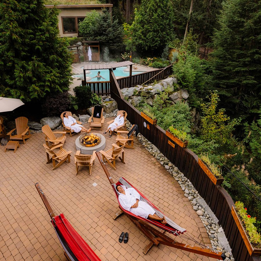 Three people relax in an outdoor pool at Scandinave Spa Whistler.